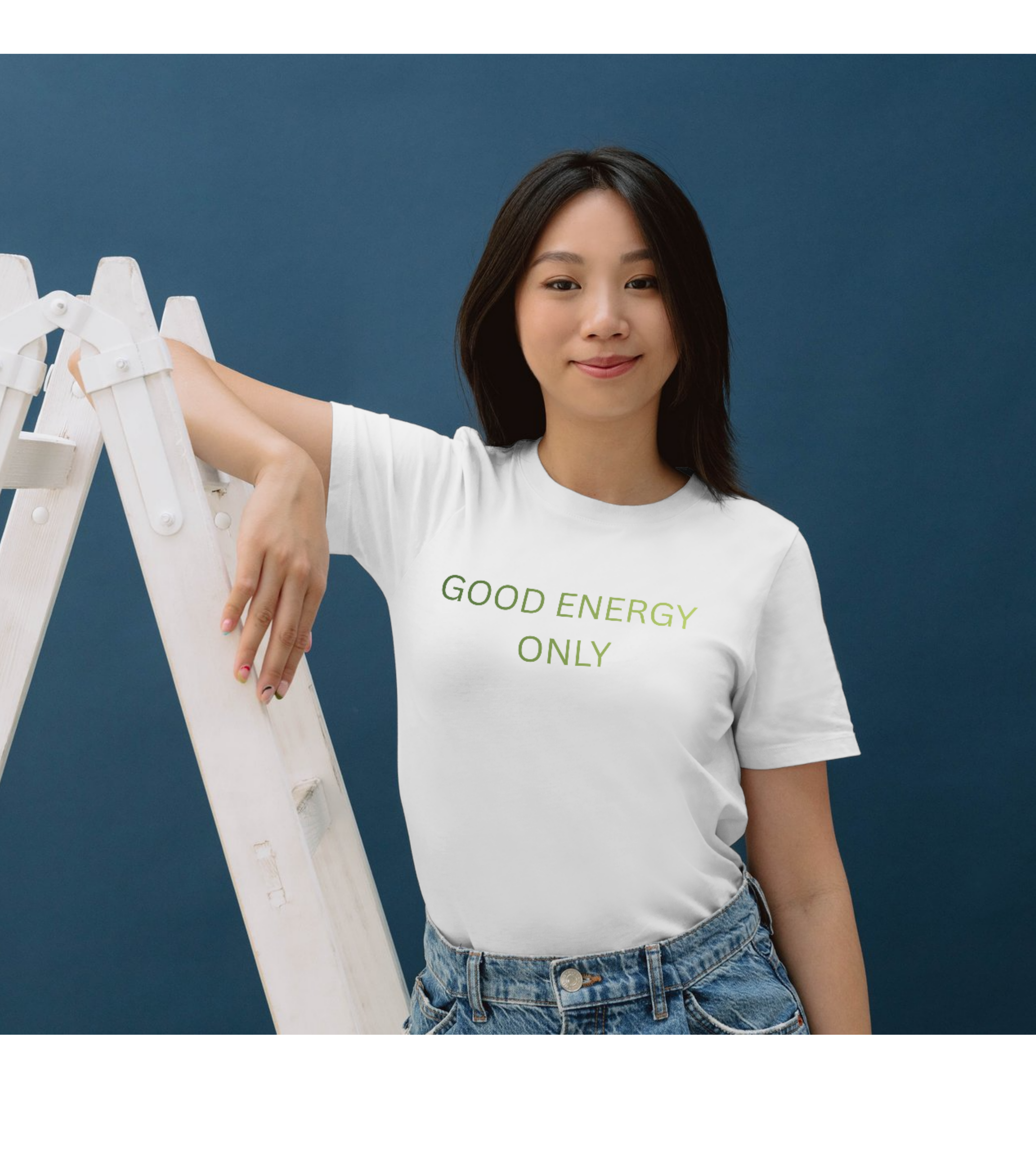 Woman wearing a white t-shirt with 'GOOD ENERGY ONLY' text against a blue background
