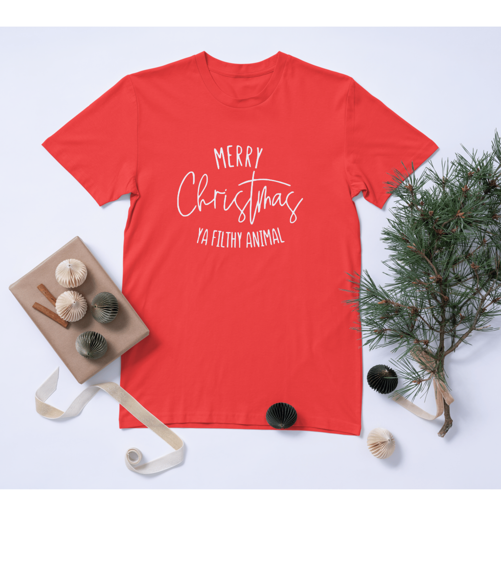 Red t-shirt with 'Merry Christmas Ya Filthy Animal' text, surrounded by Christmas decorations on a light blue background.
